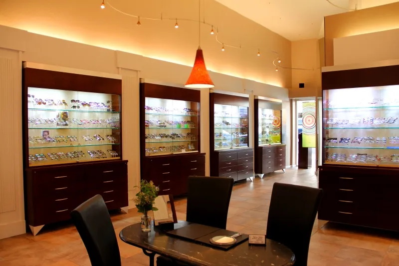The Ong Optometry showroom, with lit eyewear display cases and a small table