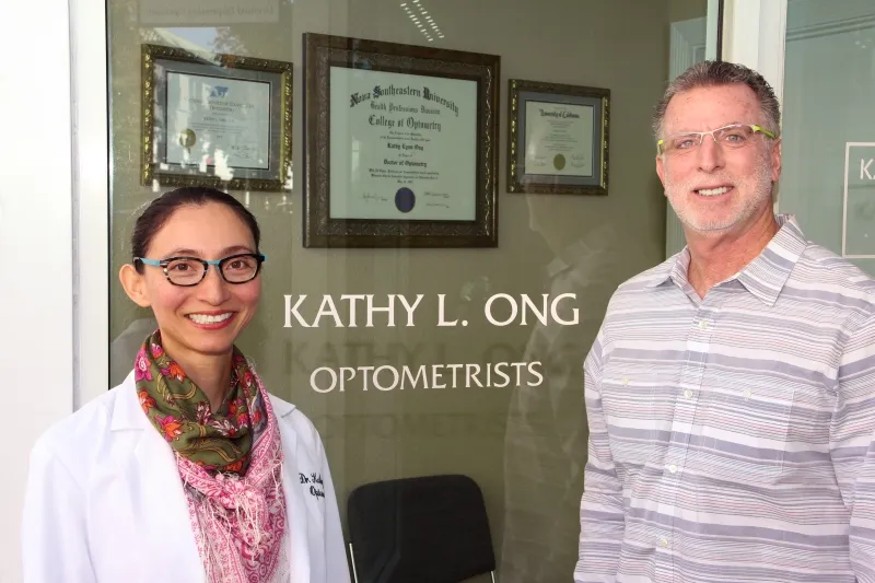 Dr. Kathy Ong and a colleague at the office door lettered Kathy L. Ong Optometrists